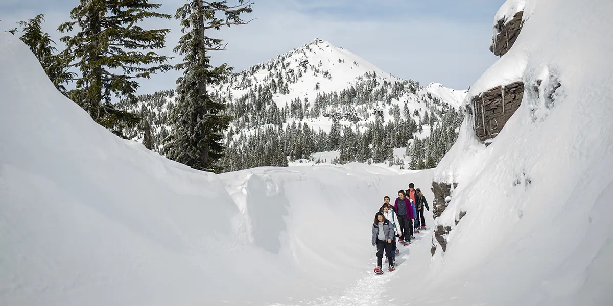 students hiking at Crater Lake in the snow.