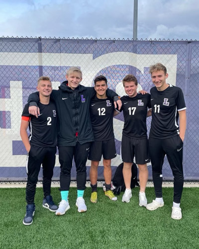 Marques with his teammates posing on a soccer field.