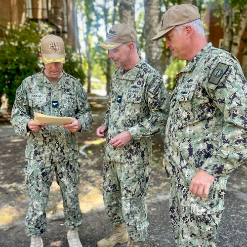 Eric Schuck looking at documents with his captain and another officer.