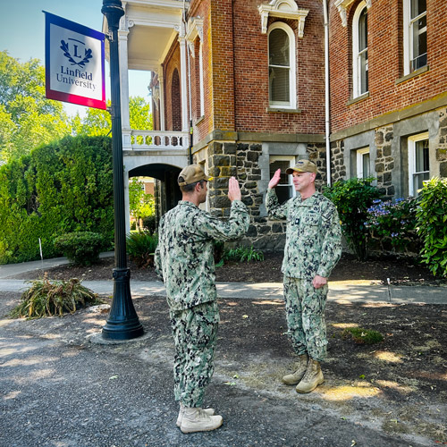 Professor Schuck saluting his captain, both wearing their Navy attire.