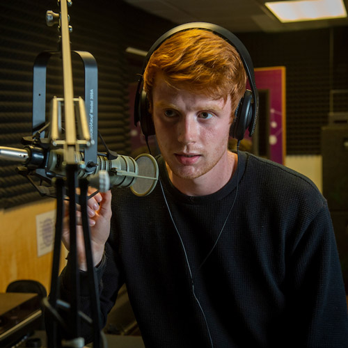 Ben O'Loughlin, executive producer with Wildcat Productions behind the microphone in the student media center