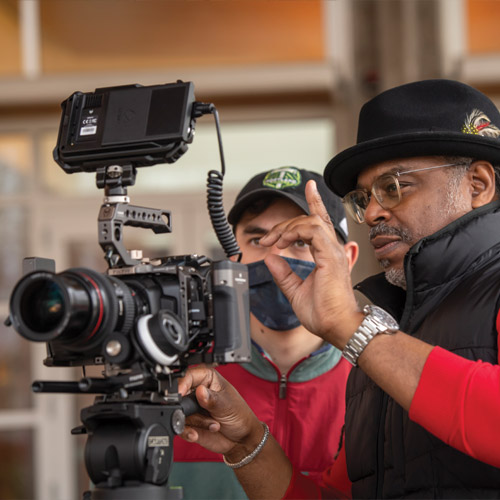 Professor Kahlil Pedizisai working with a student on a camera