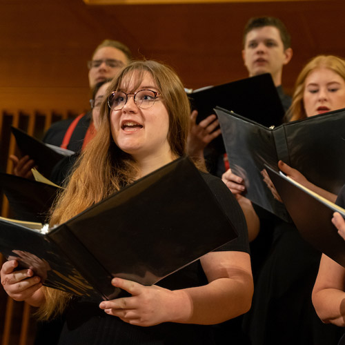 Students performing on stage in a choir recital.