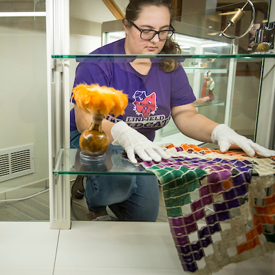 student setting up museum exhibit