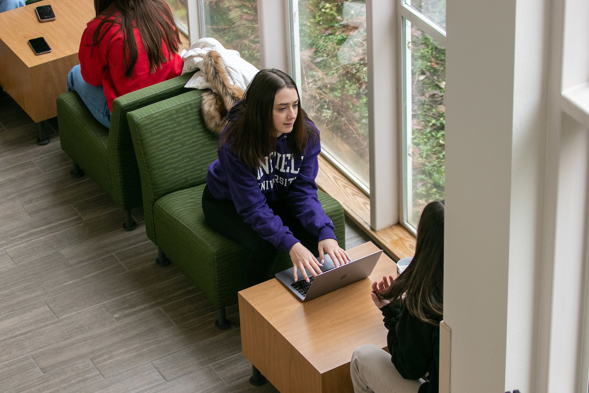 Students sitting in Keck lounge talking.