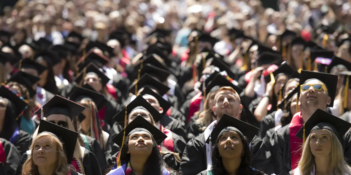 students during commencement looking up to the sky.