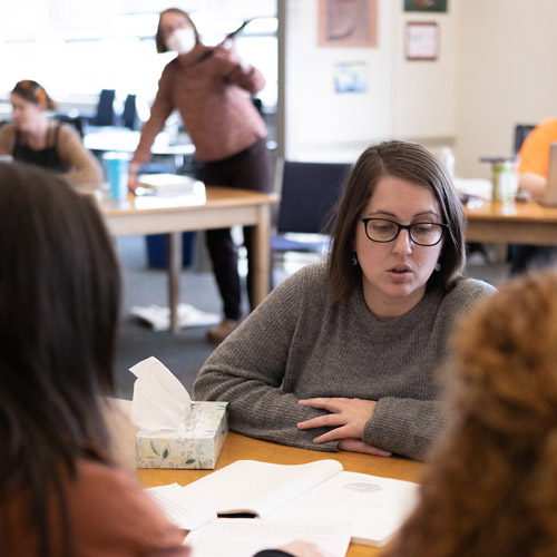 three graduate students studying together in a classroom