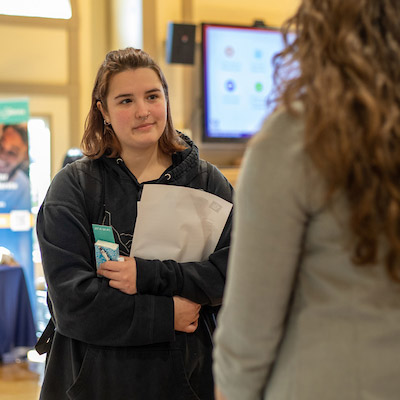 Female student speaking to employer at the Job Fair.