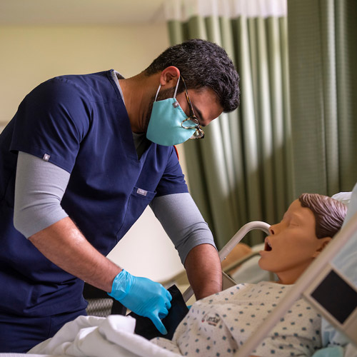 nursing student practicing on a manikin in the simulation lab