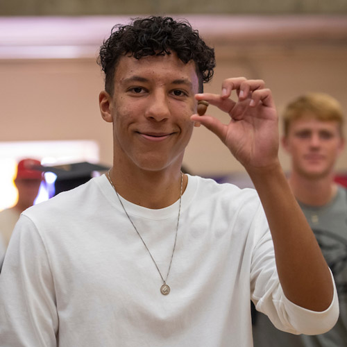 Male student showing the acorn he received at Convocation.