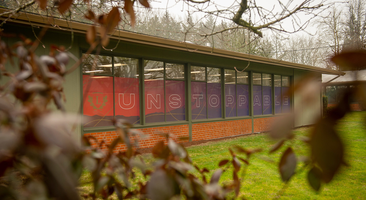 Linfield University Portland Campus building with the word "Unstoppable" across the windows.