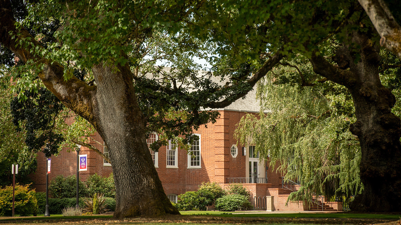 The front entrance of TJ Day Hall framed by trees..